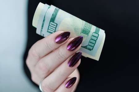 woman's hands holding American dollar paper bills