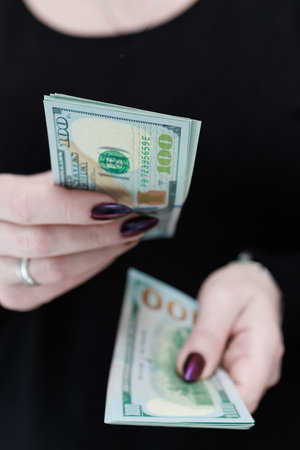 woman's hands holding American dollar paper billsの写真素材