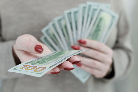 woman's hands holding American dollar paper billsの写真素材