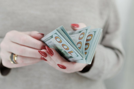 woman's hands holding American dollar paper billsの写真素材