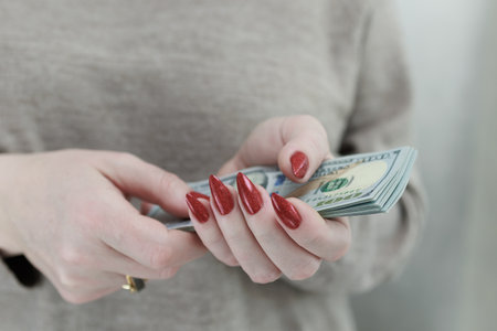 woman's hands holding American dollar paper billsの写真素材