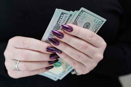woman's hands holding American dollar paper billsの写真素材