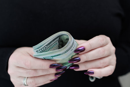 woman's hands holding American dollar paper billsの写真素材