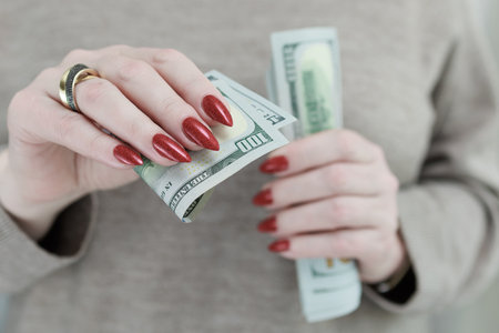 woman's hands holding American dollar paper billsの写真素材