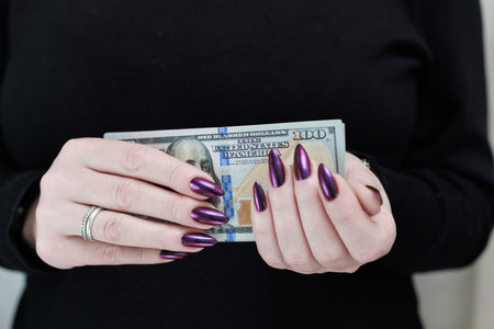 woman's hands holding American dollar paper billsの写真素材