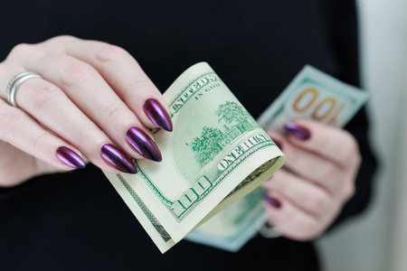 woman's hands holding American dollar paper billsの写真素材