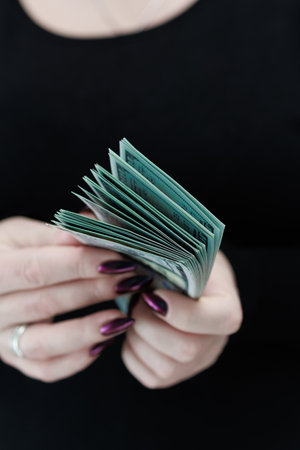 woman's hands holding American dollar paper bills