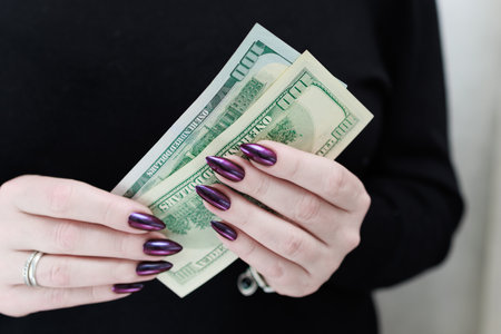 woman's hands holding American dollar paper bills