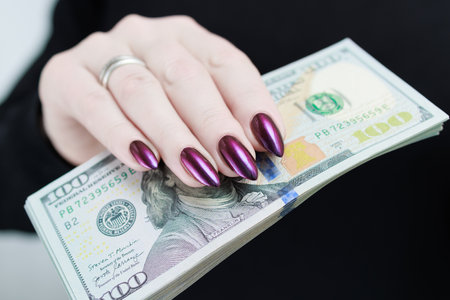 woman's hands holding American dollar paper bills