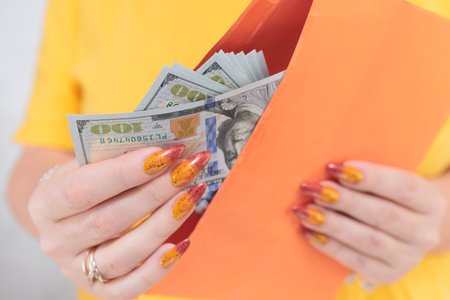 woman's hands holding American dollar paper billsの写真素材