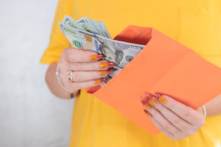 woman's hands holding American dollar paper bills