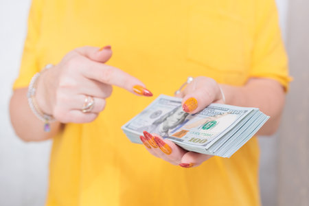woman's hands holding American dollar paper billsの写真素材