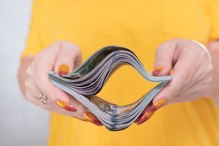 woman's hands holding American dollar paper bills