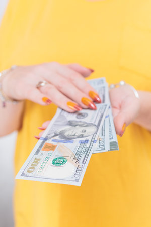 woman's hands holding American dollar paper bills