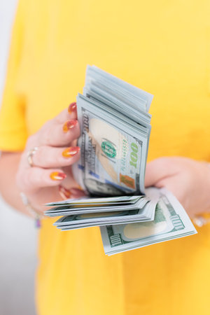 woman's hands holding American dollar paper bills