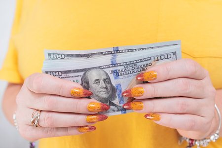 woman's hands holding American dollar paper billsの写真素材