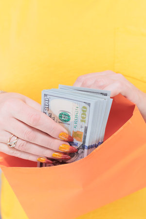 woman's hands holding American dollar paper bills