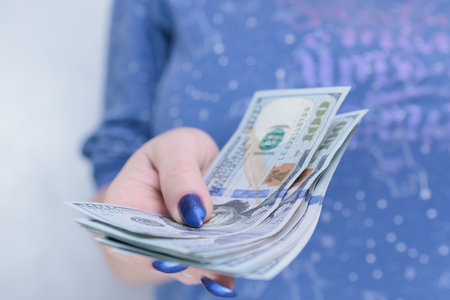woman's hands holding American dollar paper billsの写真素材