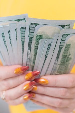 woman's hands holding American dollar paper bills