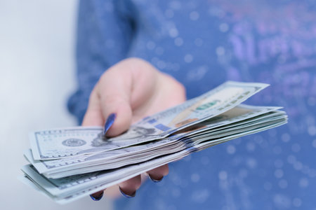 woman's hands holding American dollar paper billsの写真素材