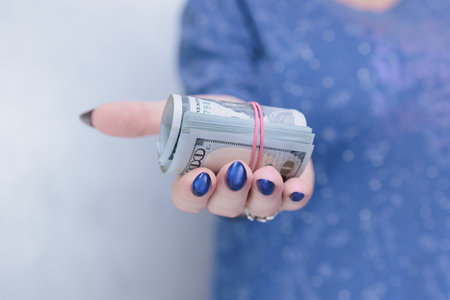 woman's hands holding American dollar paper bills