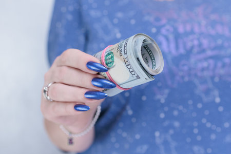 woman's hands holding American dollar paper bills