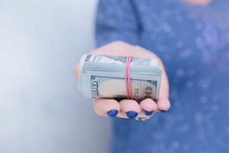 woman's hands holding American dollar paper billsの写真素材