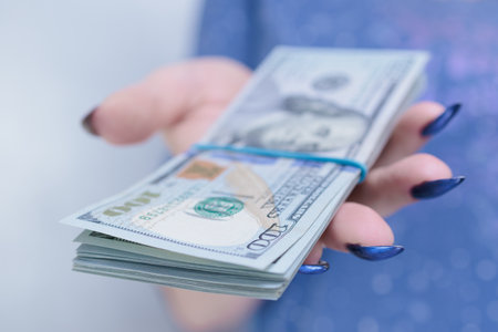 woman's hands holding American dollar paper bills