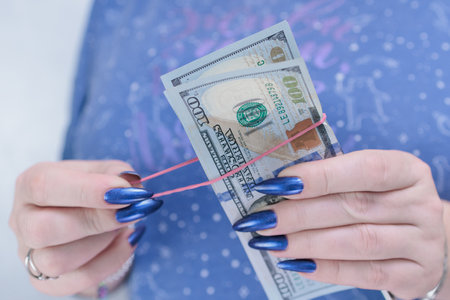 woman's hands holding American dollar paper bills