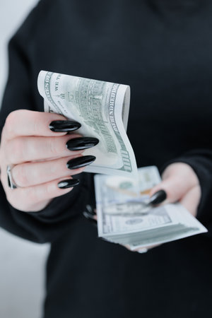 woman's hands holding American dollar paper billsの写真素材