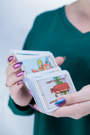 Female hands holding tarot cards for fortune telling and tricks