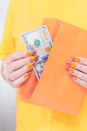 woman's hands holding American dollar paper bills