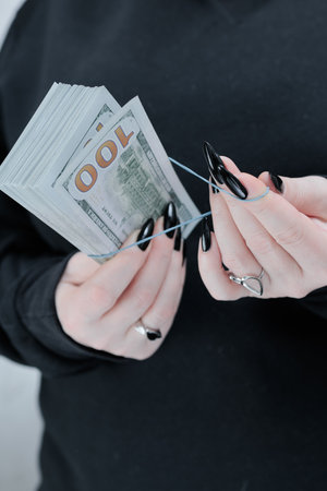 woman's hands holding American dollar paper bills