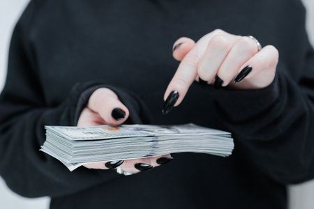 woman's hands holding American dollar paper bills