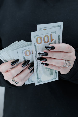 woman's hands holding American dollar paper bills