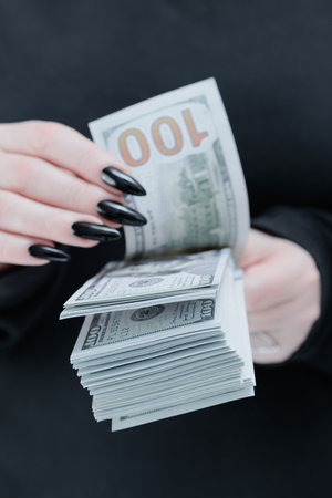 woman's hands holding American dollar paper bills
