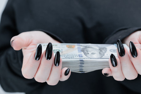 female hands holding American dollar paper billsの写真素材