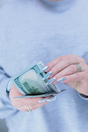 woman's hands holding American dollar paper billsの写真素材