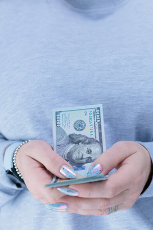 female hands holding American dollar paper billsの写真素材