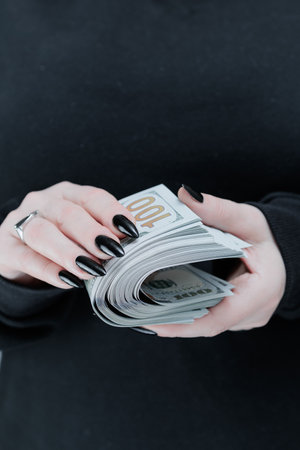 female hands holding American dollar paper billsの写真素材