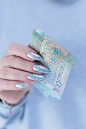 Female hands holding paper bills Belarusian rubles