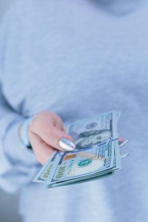 female hands holding American dollar paper bills