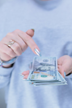 woman's hands holding American dollar paper billsの写真素材