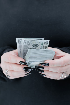 female hands holding American dollar paper billsの写真素材