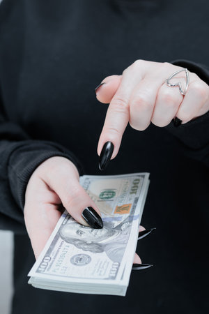 female hands holding American dollar paper billsの写真素材