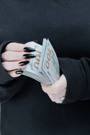 female hands holding American dollar paper billsの写真素材