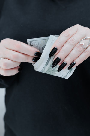female hands holding American dollar paper billsの写真素材