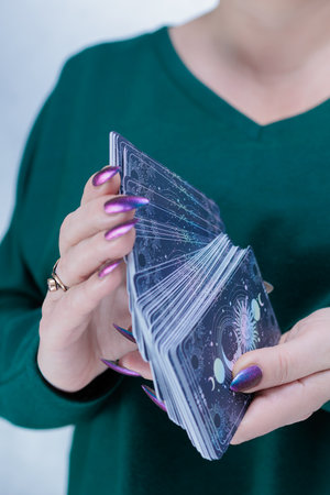 Female hands holding tarot cards for fortune telling and tricks