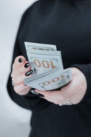 female hands holding American dollar paper billsの写真素材