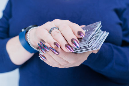 Female hands holding tarot cards for fortune telling and tricksの写真素材